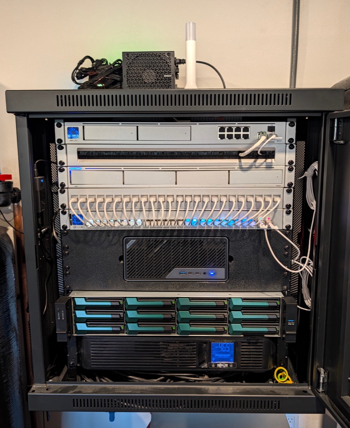 The finished server back in the rack and cabled up, the new mini PC seated in the middle of the stack.